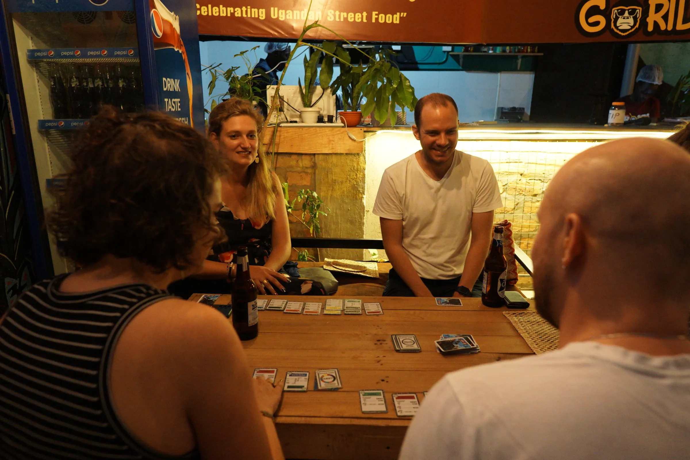 Friends playing Eyedentify around a café table at night