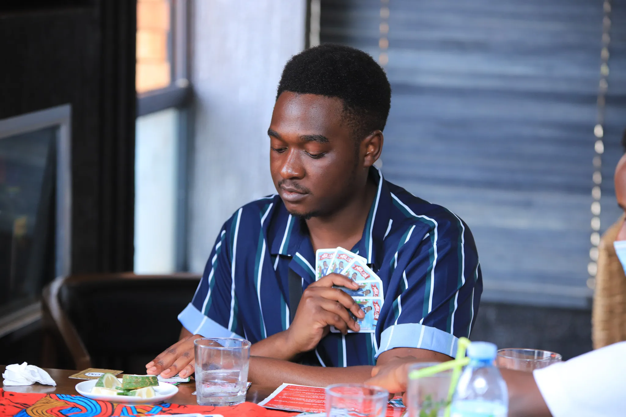 A player concentrating on his Mulodi cards